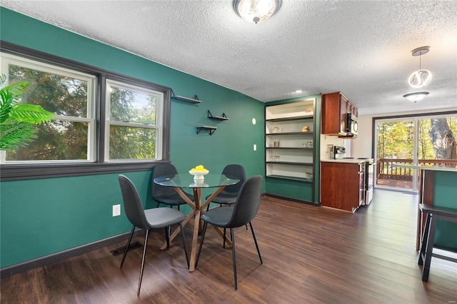 dining room featuring built in shelves, dark hardwood / wood-style floors, and a textured ceiling