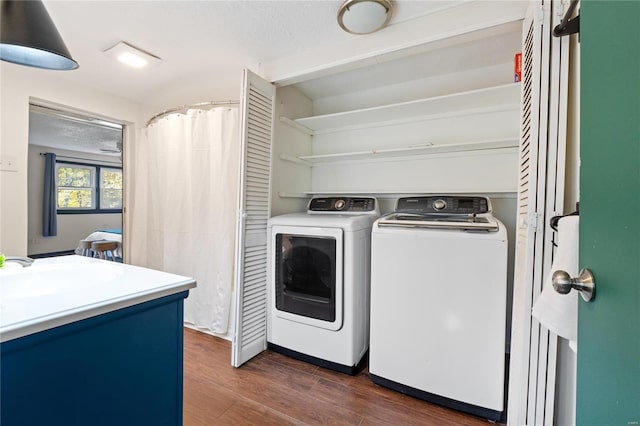 laundry room featuring dark hardwood / wood-style flooring, independent washer and dryer, and sink