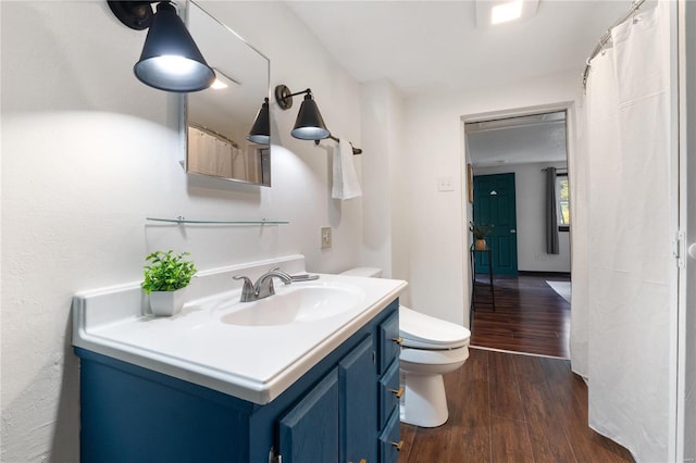 bathroom with wood-type flooring, toilet, and vanity