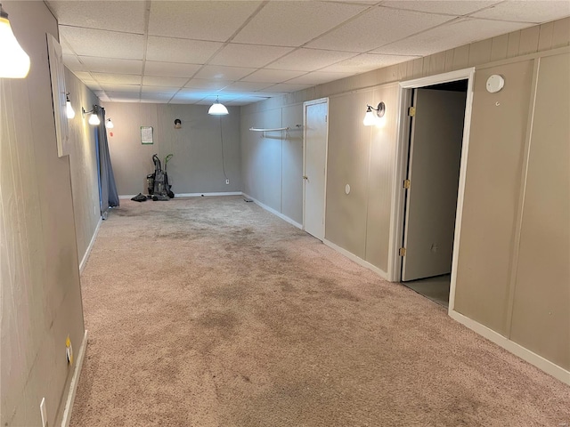 basement featuring carpet flooring and a drop ceiling