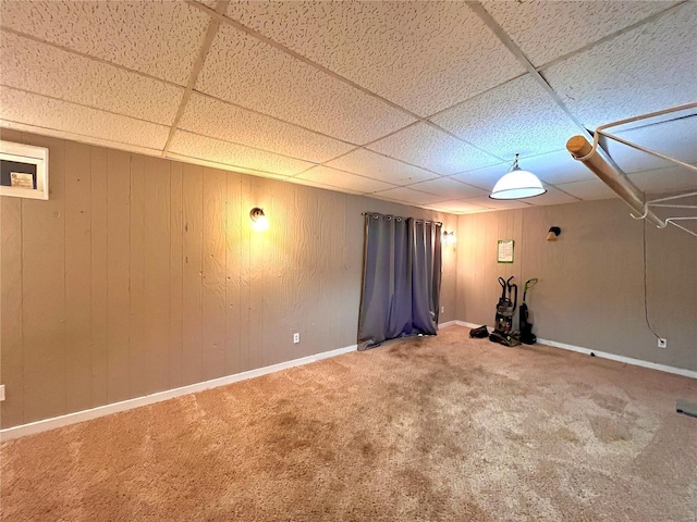 basement featuring a paneled ceiling and carpet