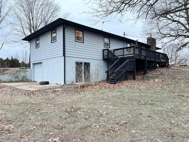 back of house with a wooden deck and a garage