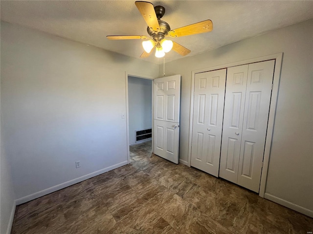 unfurnished bedroom with ceiling fan and a closet