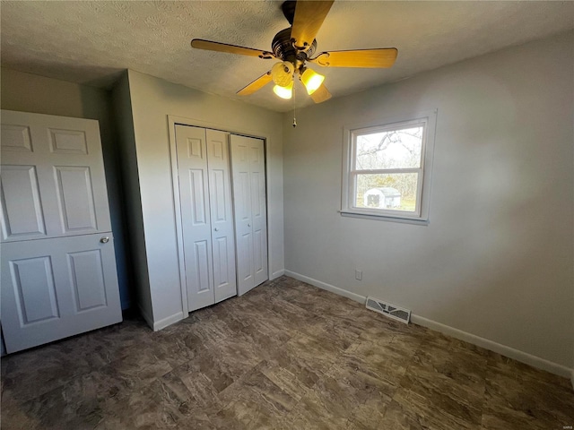 unfurnished bedroom featuring ceiling fan, a textured ceiling, and a closet