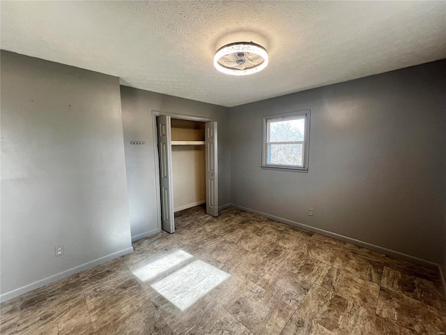 unfurnished bedroom featuring a closet and a textured ceiling