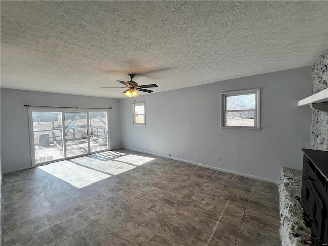 unfurnished living room with a textured ceiling and ceiling fan