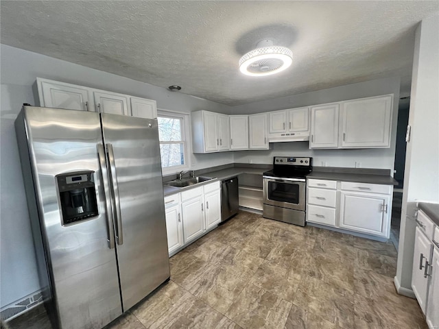 kitchen featuring stainless steel appliances, white cabinetry, sink, and a textured ceiling