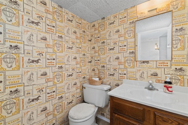 bathroom featuring vanity, toilet, and a textured ceiling