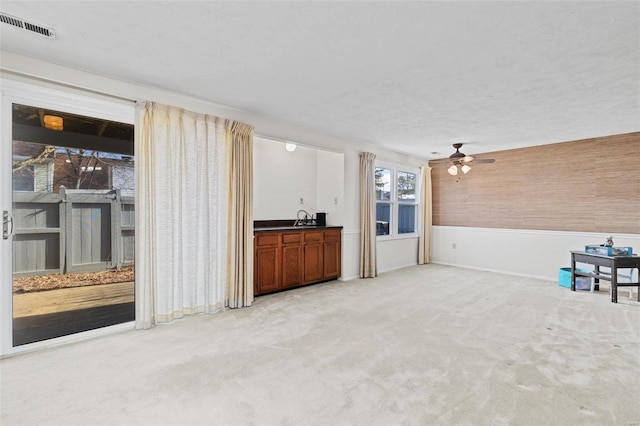 bar featuring light carpet and a textured ceiling