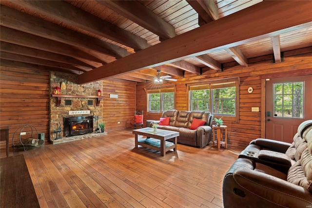 living room with wood ceiling, wooden walls, light wood-type flooring, a fireplace, and beamed ceiling