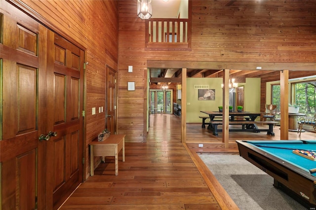 rec room featuring hardwood / wood-style flooring, a high ceiling, billiards, and wooden walls