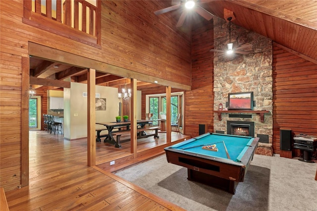 playroom featuring high vaulted ceiling, plenty of natural light, and wood walls