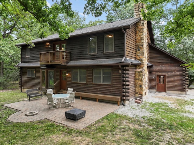 back of property featuring a patio area, a lawn, and a balcony