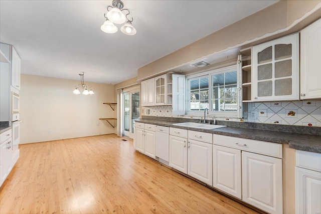 kitchen featuring white cabinetry, sink, white appliances, and an inviting chandelier