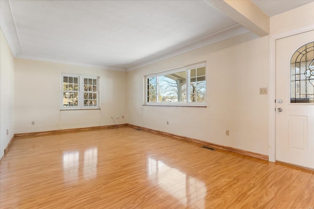 entrance foyer featuring ornamental molding and light hardwood / wood-style floors