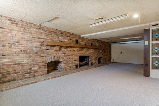 basement with brick wall, carpet floors, and a fireplace