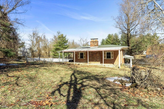 back of house featuring a patio area and a lawn