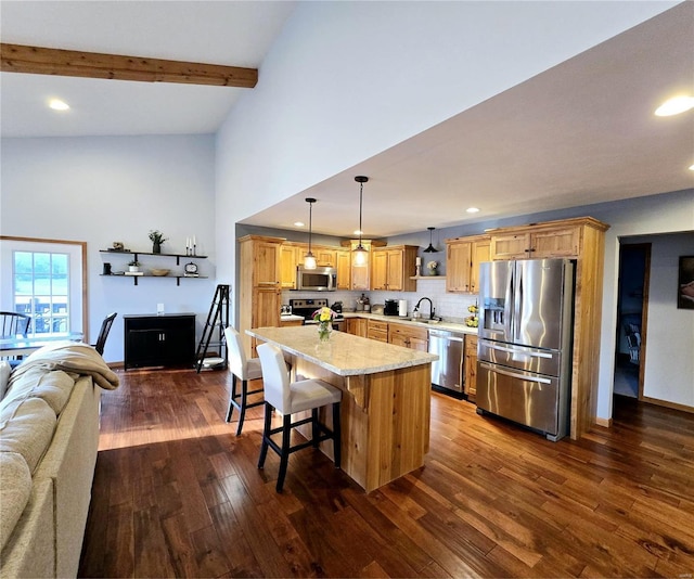 kitchen with appliances with stainless steel finishes, a breakfast bar, pendant lighting, sink, and beam ceiling