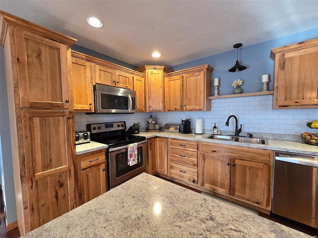 kitchen with pendant lighting, sink, decorative backsplash, stainless steel appliances, and light stone countertops