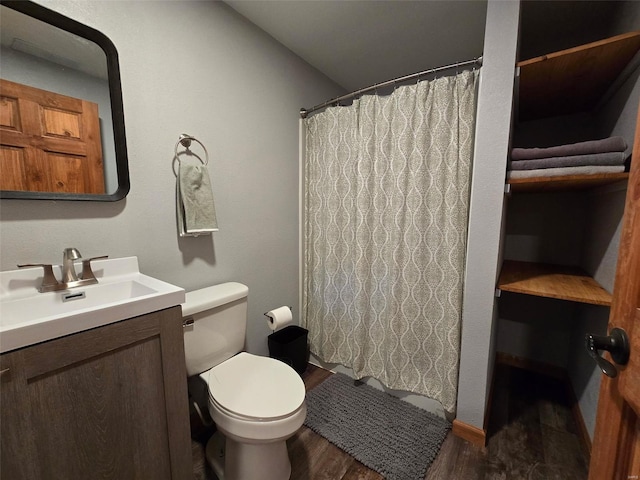 bathroom featuring walk in shower, vanity, toilet, and hardwood / wood-style floors