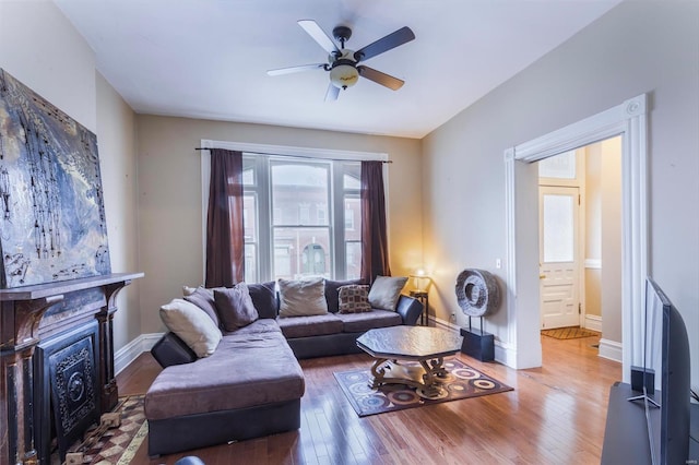 living room with ceiling fan, a fireplace, and hardwood / wood-style floors