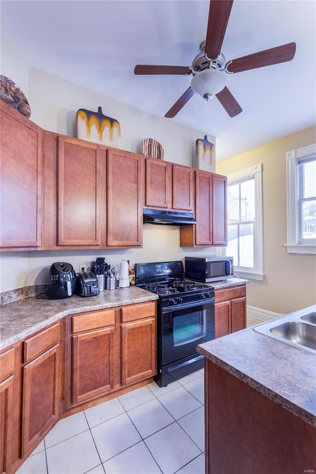 kitchen with ceiling fan, black range with gas stovetop, and light tile patterned flooring