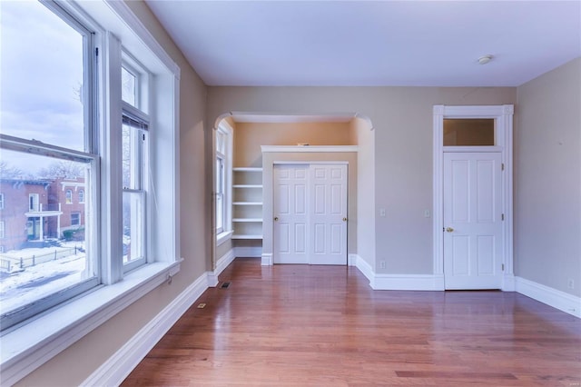 unfurnished room with wood-type flooring and a wealth of natural light