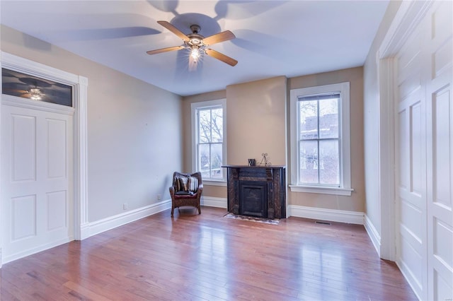 living area featuring ceiling fan, a wealth of natural light, and light hardwood / wood-style flooring