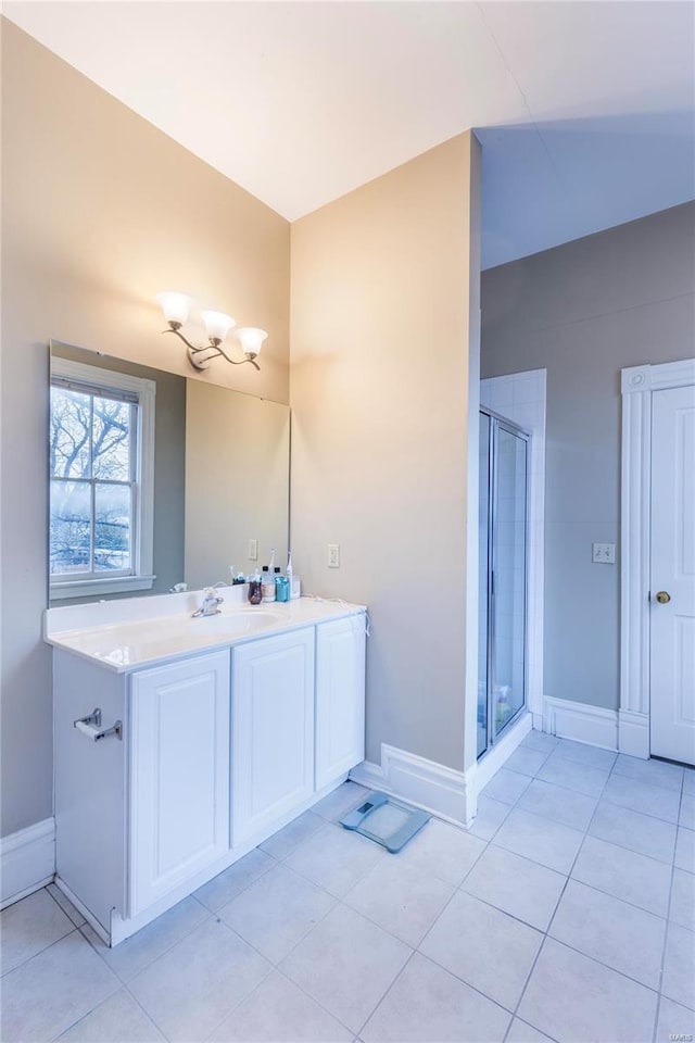 bathroom featuring tile patterned flooring, a shower with shower door, and vanity