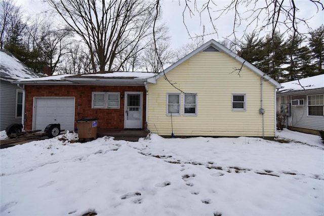 snow covered property with a garage