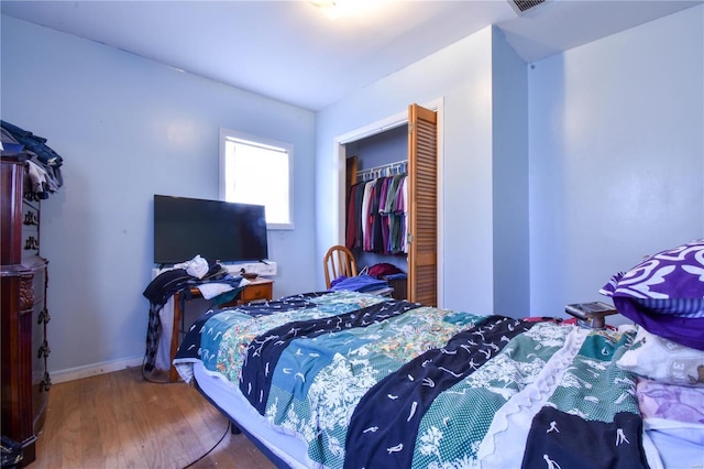 bedroom with a closet and hardwood / wood-style floors