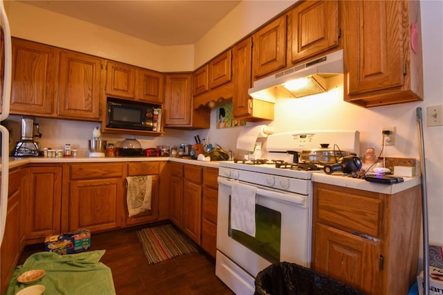 kitchen featuring dark wood-type flooring, black microwave, and white range with gas stovetop