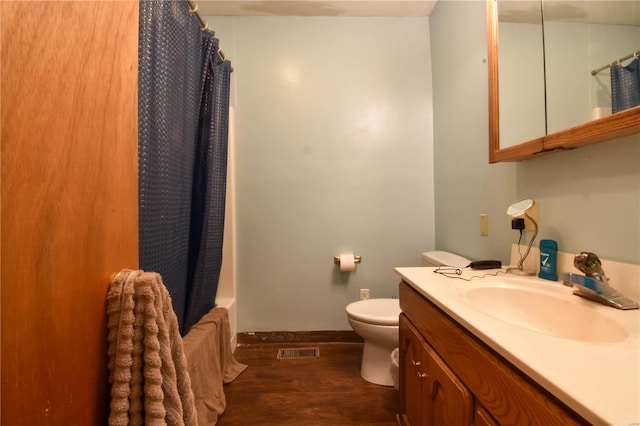 full bathroom featuring shower / bath combo with shower curtain, wood-type flooring, toilet, and vanity