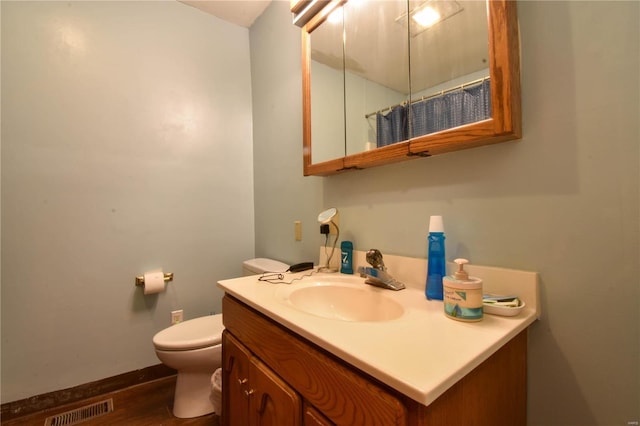 bathroom with wood-type flooring, toilet, and vanity