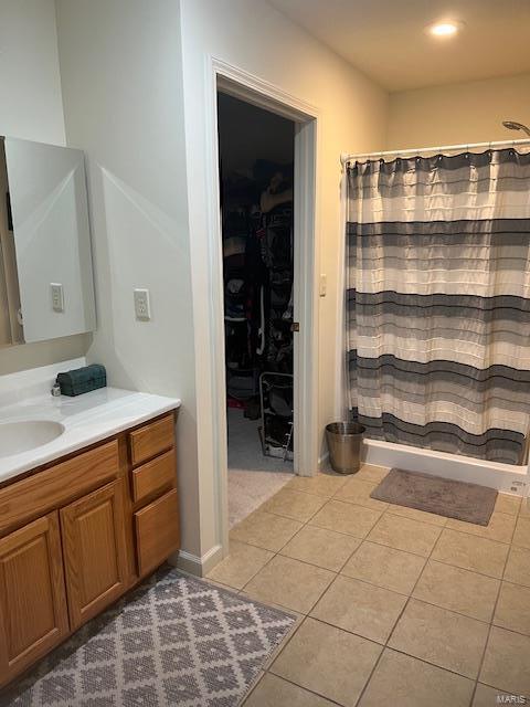 bathroom with walk in shower, tile patterned floors, and vanity