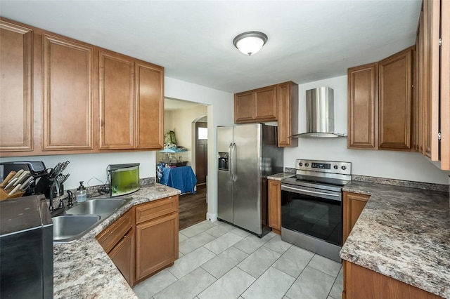 kitchen featuring light tile patterned floors, stainless steel appliances, light stone countertops, wall chimney exhaust hood, and sink