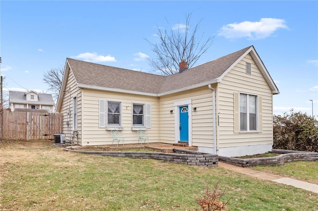 bungalow featuring cooling unit and a front lawn