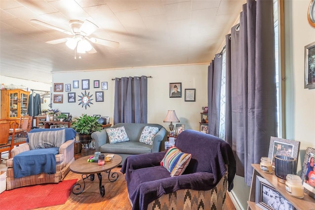 living room featuring hardwood / wood-style floors, ornamental molding, and ceiling fan