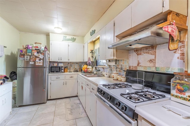 kitchen featuring sink, stainless steel refrigerator, white range with gas stovetop, white cabinetry, and decorative backsplash