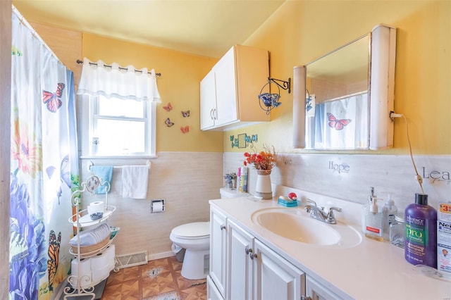 bathroom with vanity, parquet floors, tile walls, and toilet