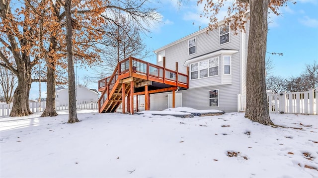 snow covered house featuring a deck