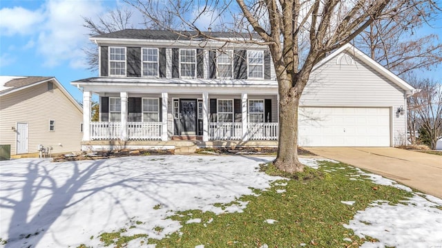 colonial-style house featuring covered porch and a garage