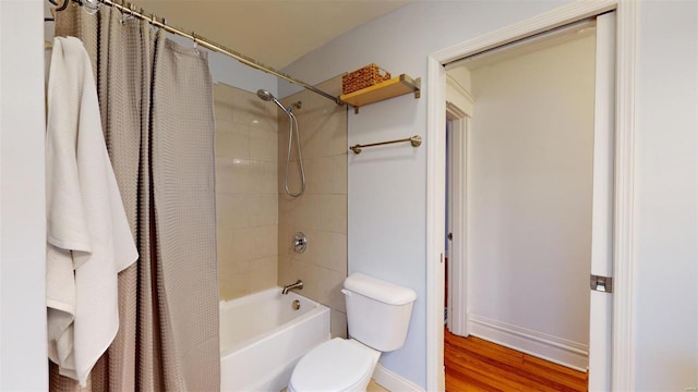 bathroom with hardwood / wood-style floors, shower / tub combo with curtain, and toilet