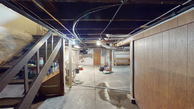 basement featuring wooden walls