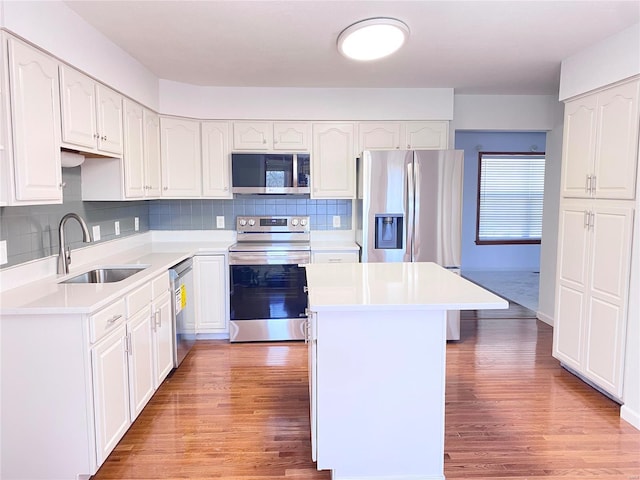 kitchen featuring light hardwood / wood-style floors, a center island, sink, white cabinetry, and appliances with stainless steel finishes