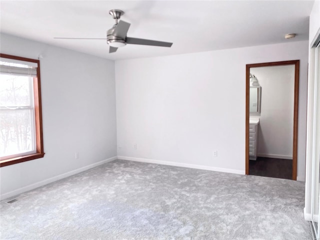 carpeted empty room with ceiling fan and plenty of natural light