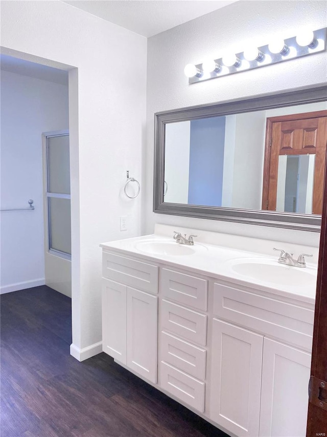 bathroom featuring hardwood / wood-style floors, vanity, and shower / bath combination with glass door