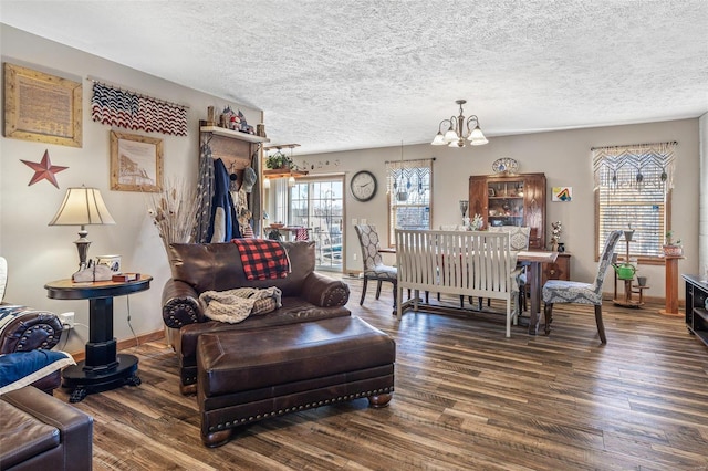 living room with a textured ceiling, dark wood-type flooring, and a notable chandelier