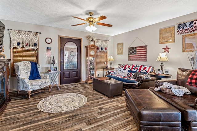 living room with hardwood / wood-style flooring, a textured ceiling, and ceiling fan