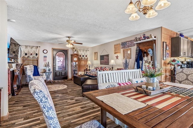 dining area featuring a textured ceiling, dark hardwood / wood-style flooring, and ceiling fan with notable chandelier